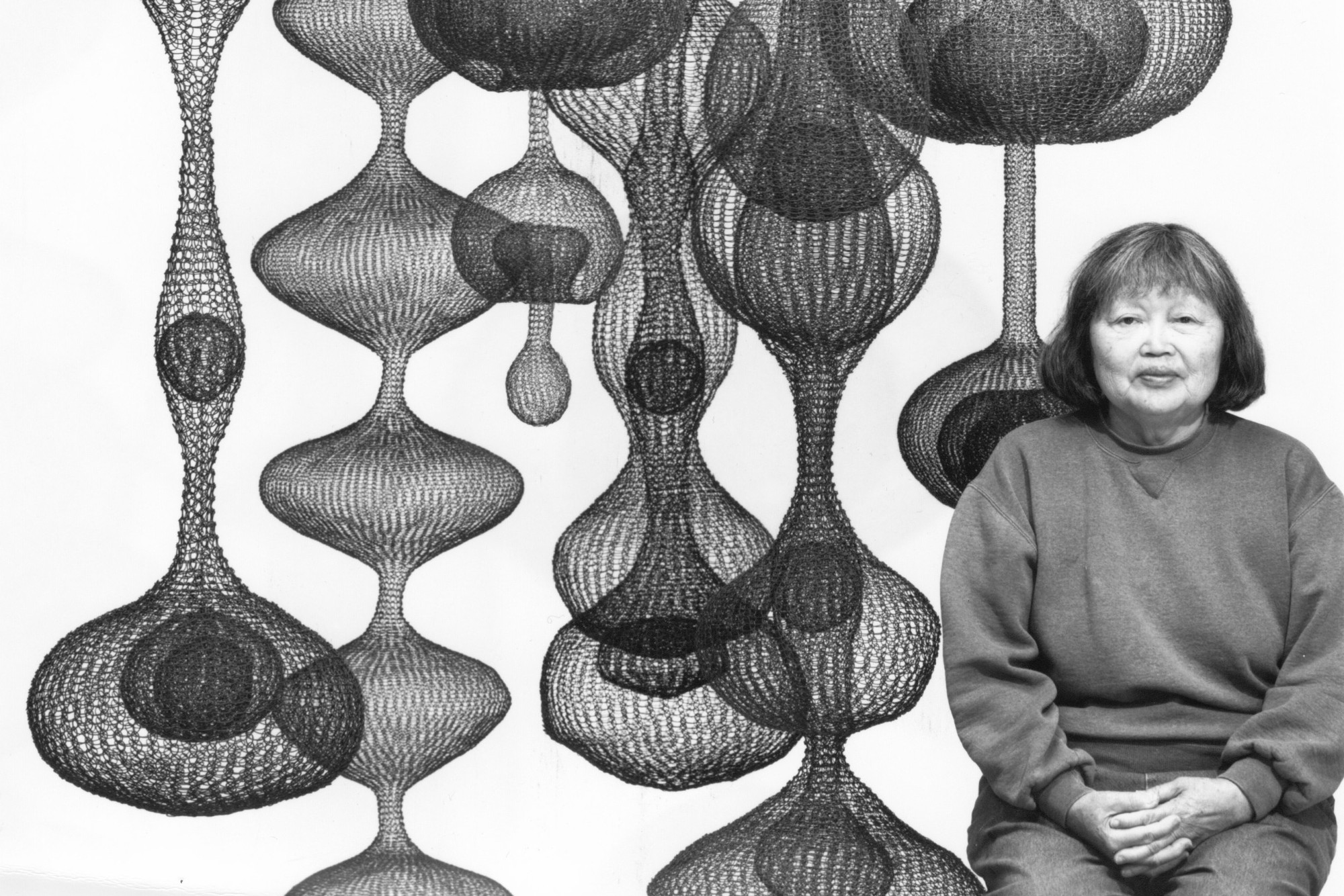 Ruth Asawa pictured with her most recognizable works, looped-wire hanging sculptures. (Courtesy of RAL, Inc.)