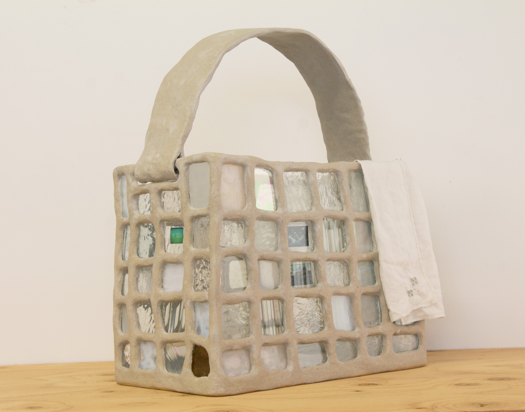  Mareiwa Miller, What Remains (Purse 1), 2024, ceramic, glass, negative, handkerchief, 17 1/4 x 14 1/2 x 8 1/4 in. 